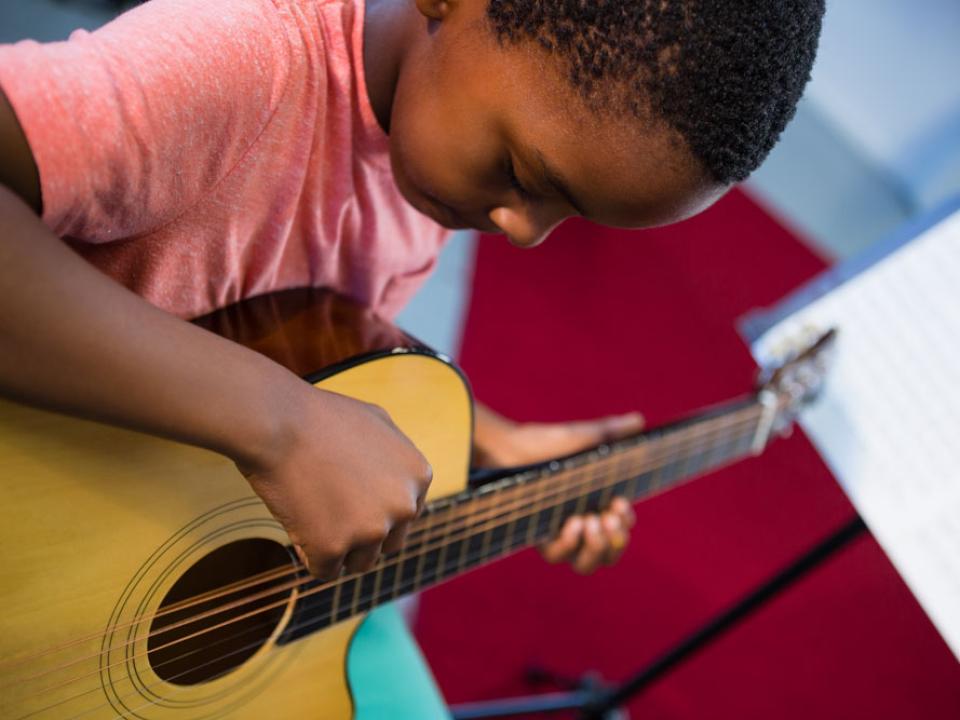 High angle view of a teen boy playing guitar