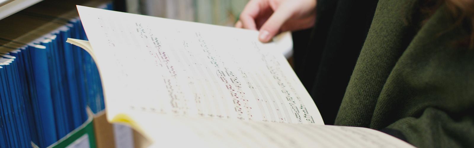 Student with open music score in library