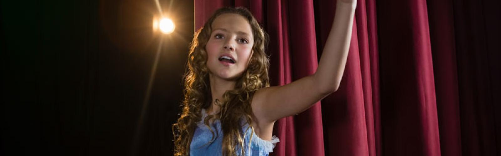 Female artist singing song on stage in theatre